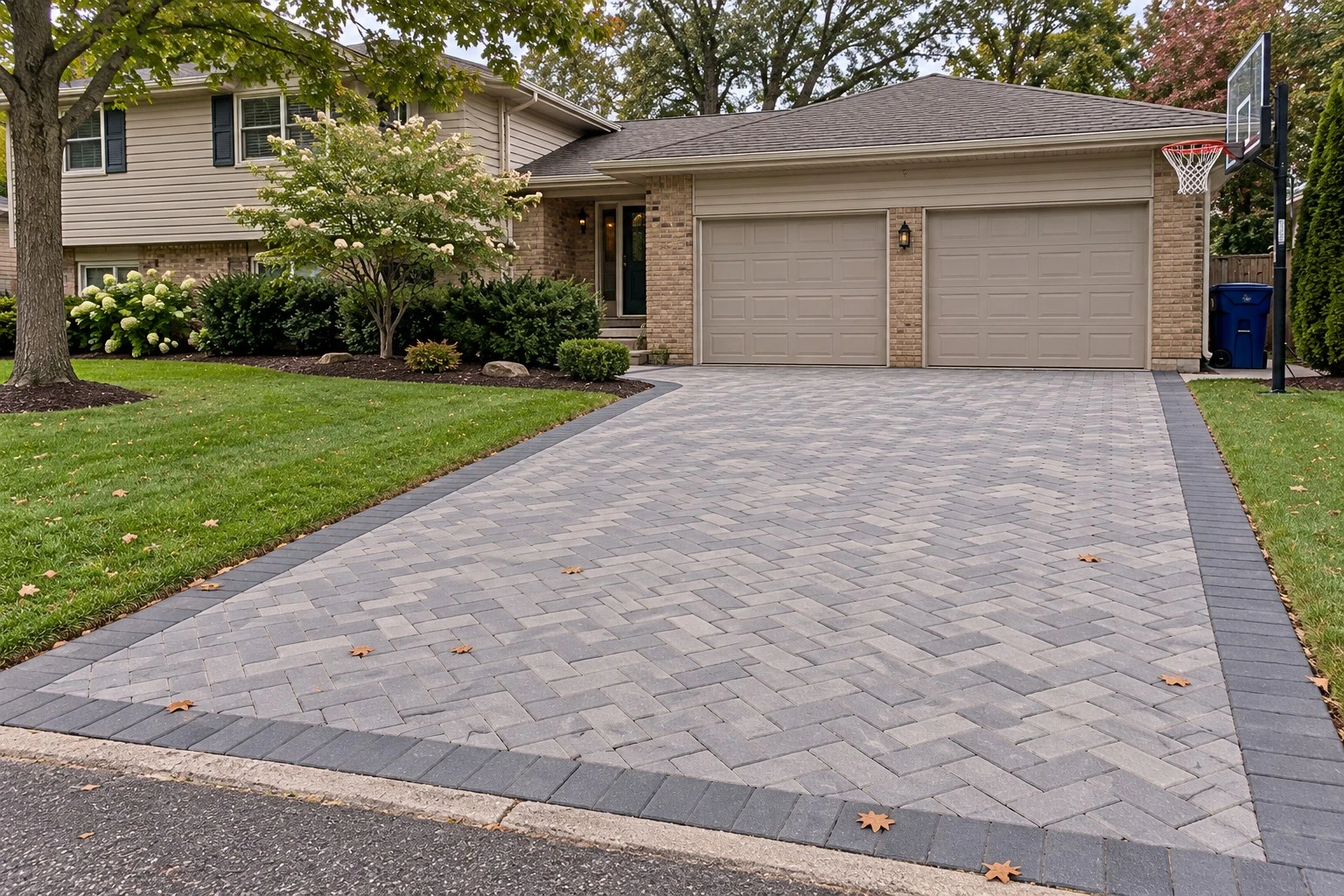 Paver driveway with a darker border in front of a two-car garage